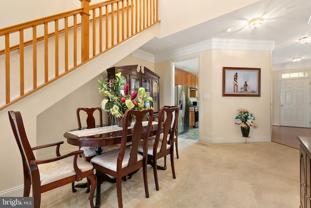 dining space with light carpet and ornamental molding