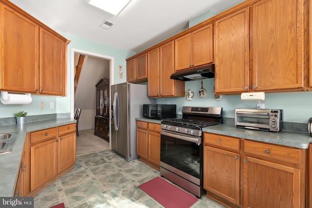 kitchen with appliances with stainless steel finishes, stainless steel counters, and sink