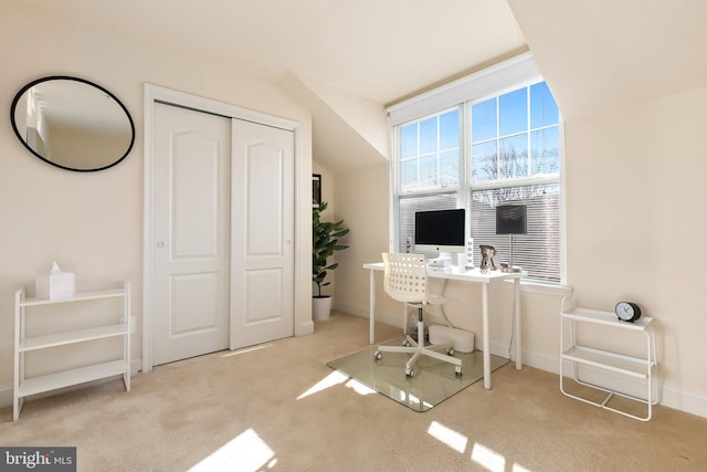 carpeted home office with vaulted ceiling