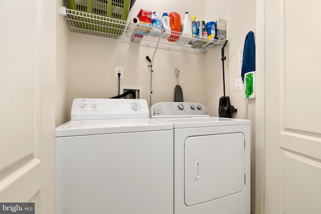 clothes washing area with washing machine and dryer