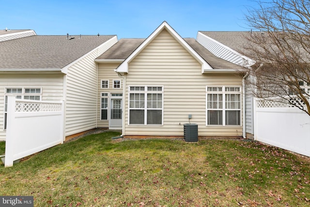 rear view of house with a yard and central AC