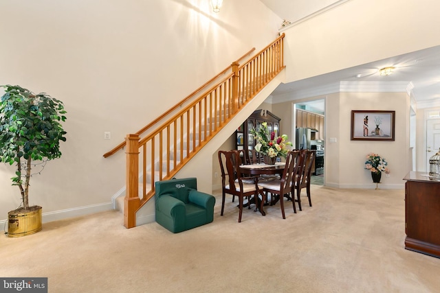 carpeted dining area featuring crown molding