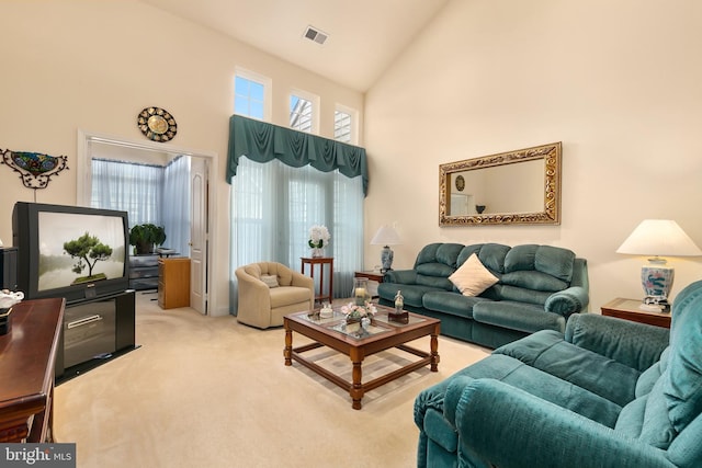 carpeted living room featuring a towering ceiling and a wealth of natural light