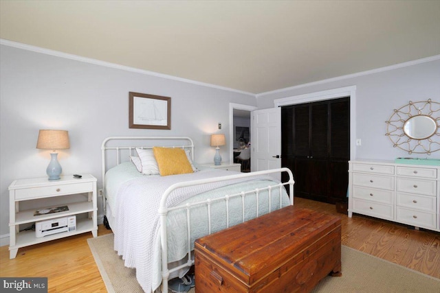 bedroom with crown molding and light hardwood / wood-style flooring