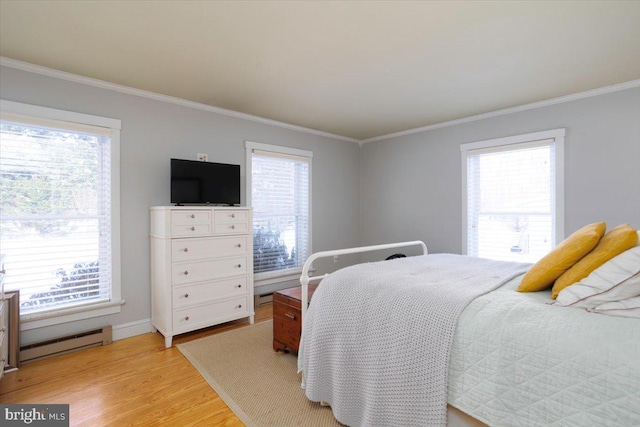 bedroom with ornamental molding, light wood-type flooring, and a baseboard heating unit