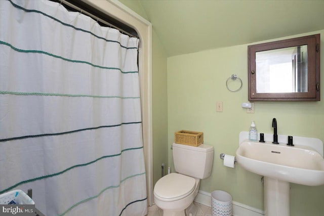 bathroom featuring tile patterned floors, toilet, lofted ceiling, and sink