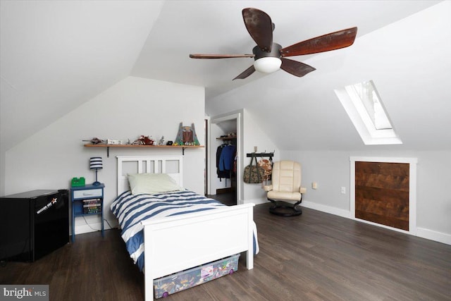 bedroom with a spacious closet, a closet, ceiling fan, and lofted ceiling with skylight