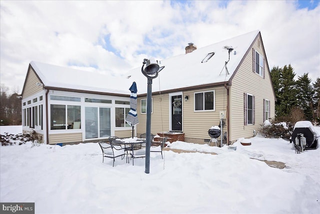 view of snow covered back of property