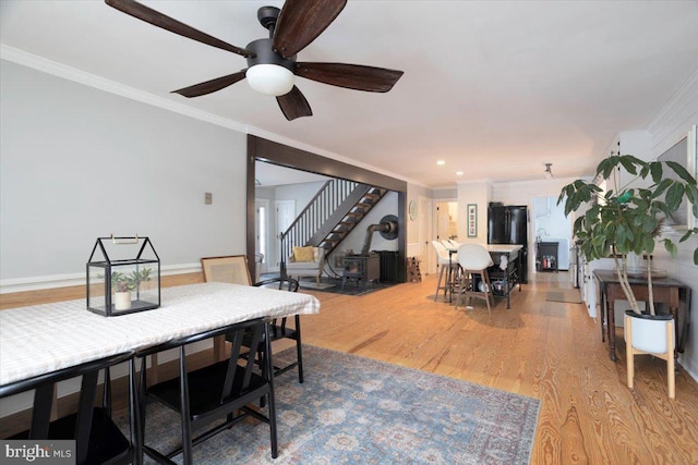 dining area with hardwood / wood-style flooring, ceiling fan, and ornamental molding