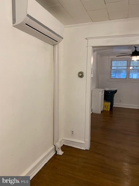 hall with a wall unit AC and dark wood-type flooring