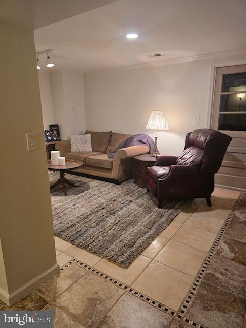 tiled living room featuring ornamental molding