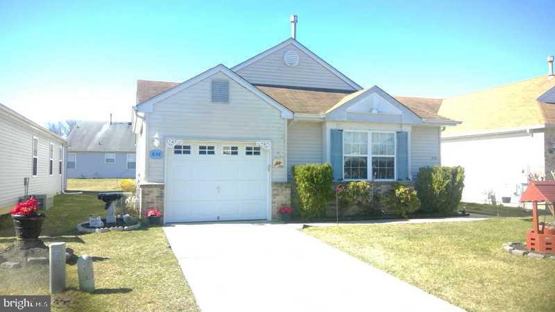 view of front of property featuring a garage, a front yard, and central AC