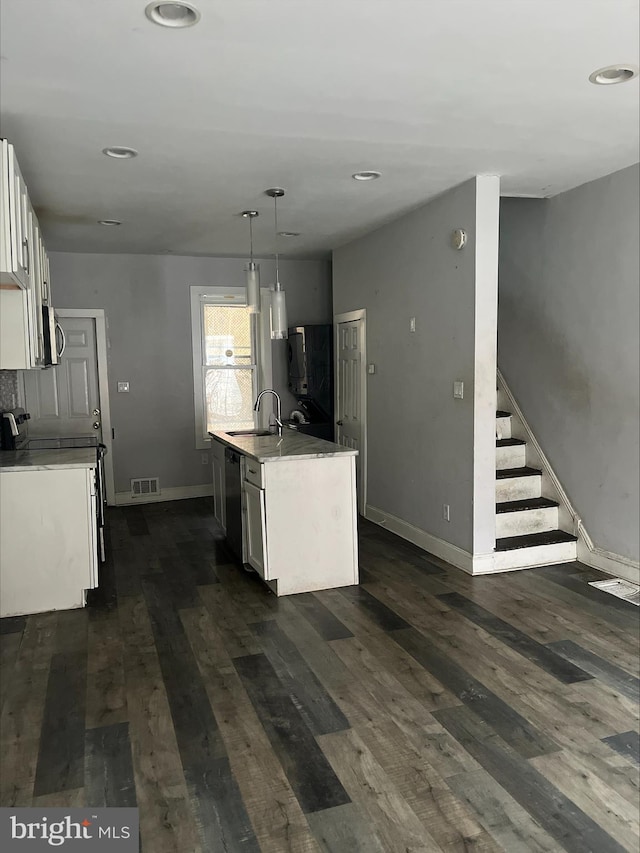 kitchen with white cabinetry, sink, hanging light fixtures, a center island with sink, and range