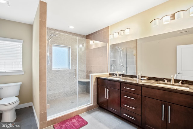 bathroom with tile patterned flooring, vanity, a shower with shower door, and toilet