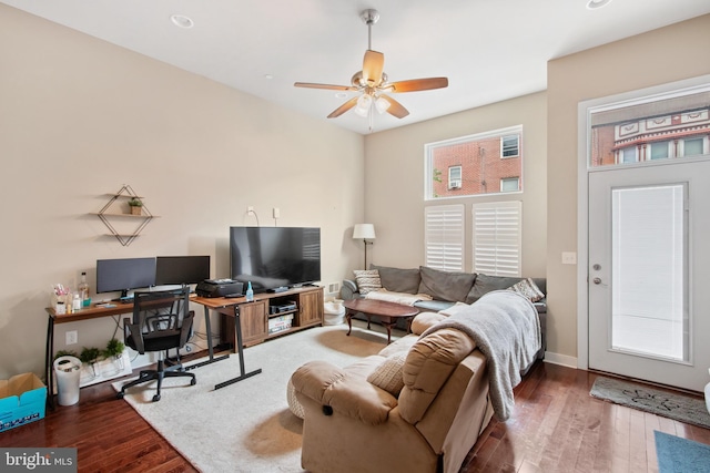 living room with ceiling fan and dark wood-type flooring