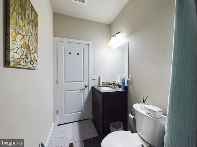 bathroom featuring tile patterned flooring, vanity, and toilet