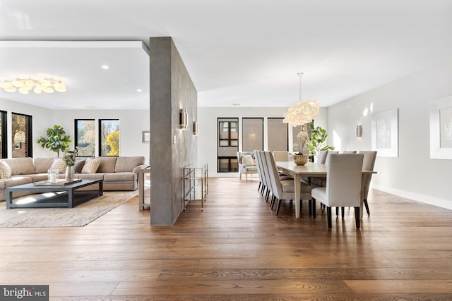 dining area with a notable chandelier, baseboards, and wood finished floors