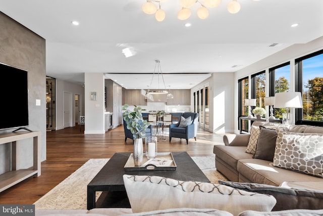 living room with baseboards, wood finished floors, and recessed lighting