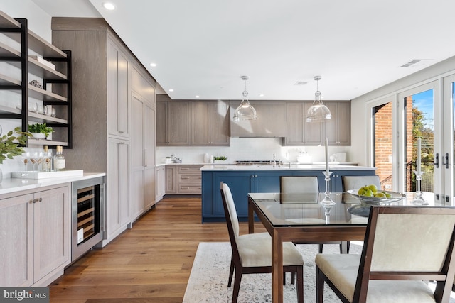 dining space with light wood finished floors, beverage cooler, visible vents, and recessed lighting