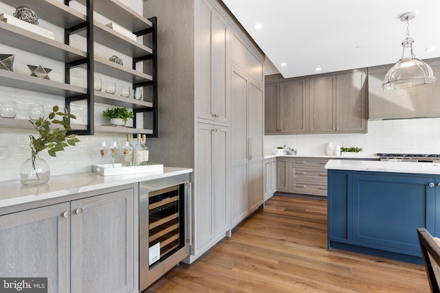 kitchen with wood finished floors, beverage cooler, light countertops, and open shelves