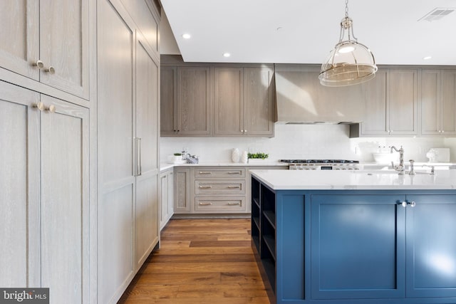 kitchen featuring open shelves, wood finished floors, visible vents, decorative backsplash, and wall chimney exhaust hood