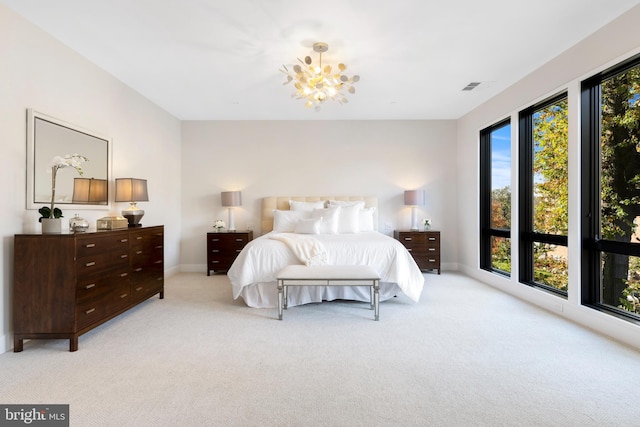 bedroom featuring a chandelier, light colored carpet, visible vents, and baseboards