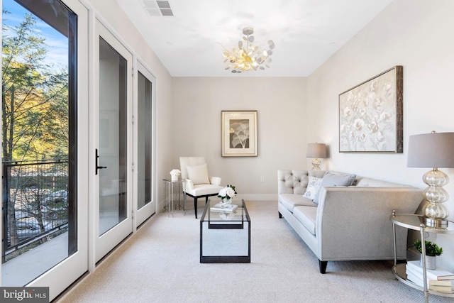 living area with french doors, visible vents, an inviting chandelier, light carpet, and baseboards