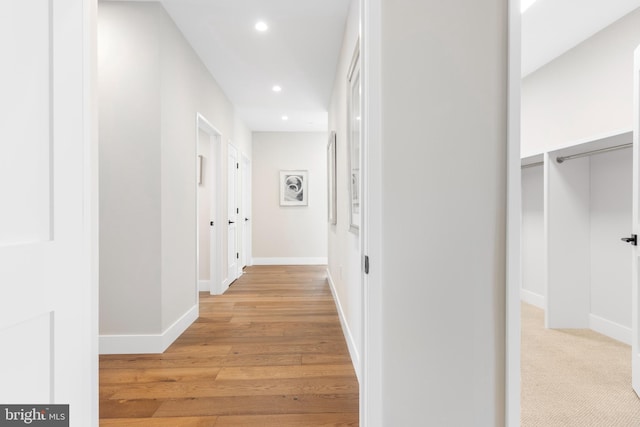 corridor featuring light wood-type flooring, baseboards, and recessed lighting