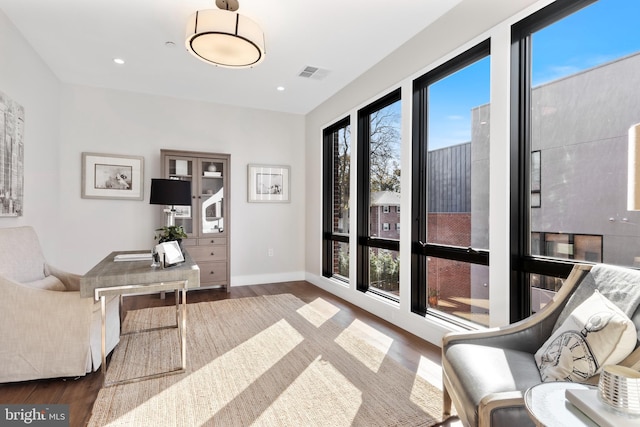 sitting room featuring baseboards, visible vents, and wood finished floors