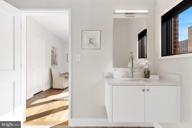 bathroom featuring visible vents, wood finished floors, vanity, and baseboards