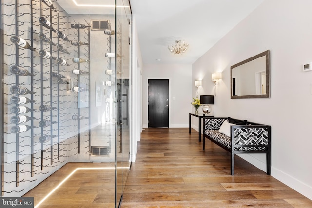 corridor featuring baseboards, visible vents, and wood finished floors