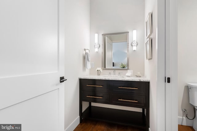 bathroom featuring vanity, baseboards, and wood finished floors