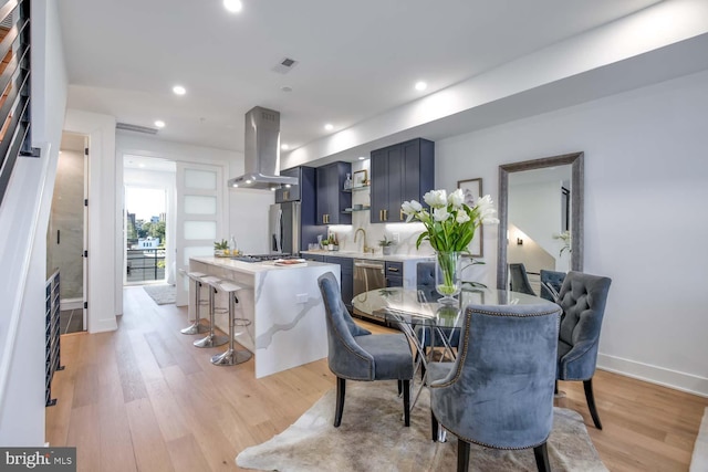 dining space with sink and light hardwood / wood-style floors