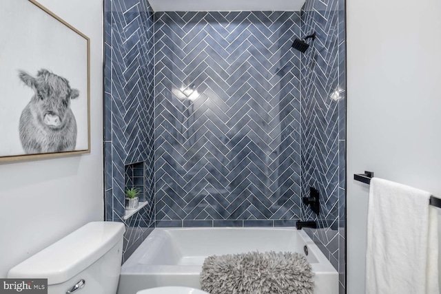 bathroom featuring tiled shower / bath combo and toilet