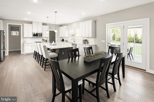 dining room with light hardwood / wood-style flooring and a healthy amount of sunlight