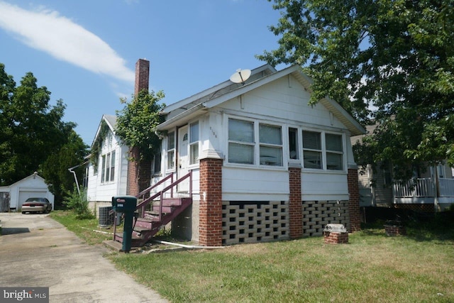 view of home's exterior with a yard, an outbuilding, and a garage