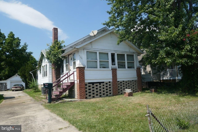 view of property exterior with an outbuilding, a garage, and a lawn