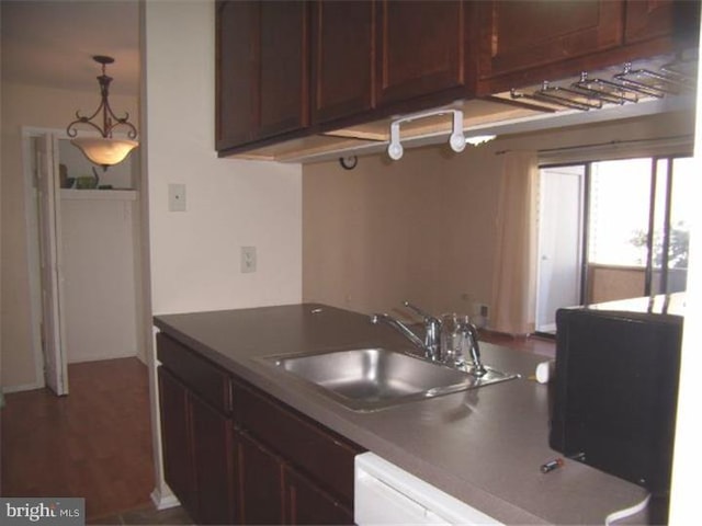 kitchen with dark brown cabinets, hanging light fixtures, and sink