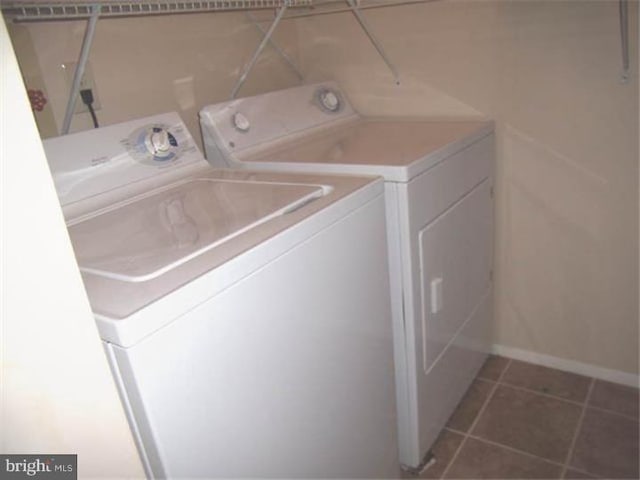 clothes washing area featuring tile patterned flooring and separate washer and dryer