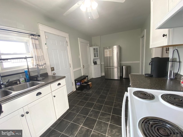 kitchen featuring white electric range, ventilation hood, white cabinetry, sink, and stainless steel fridge