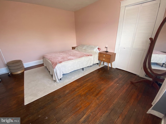 bedroom featuring dark wood-type flooring and a closet