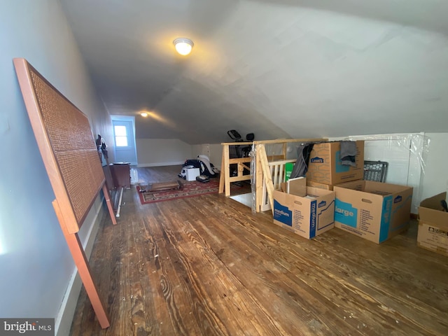 bonus room with vaulted ceiling and dark hardwood / wood-style floors