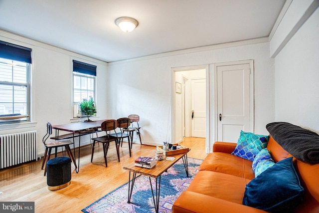 living room featuring radiator heating unit, crown molding, and hardwood / wood-style floors