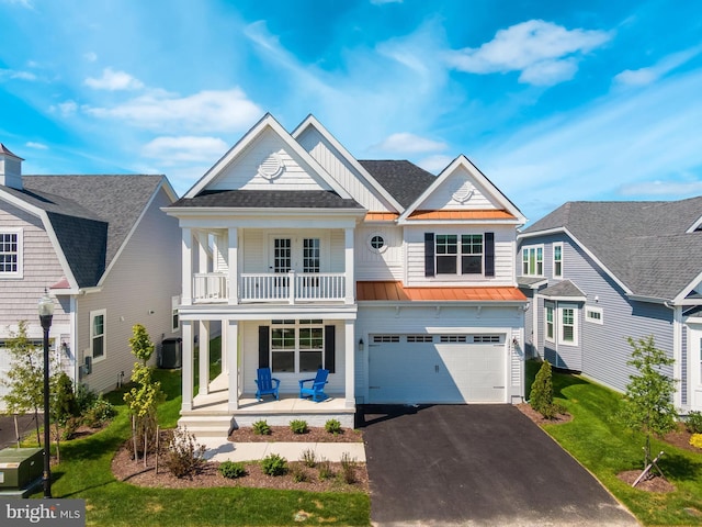 view of front of house featuring a porch, a garage, a balcony, and a front lawn