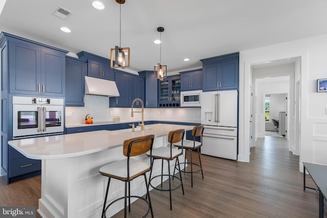 kitchen featuring blue cabinetry, built in microwave, wall oven, high end white refrigerator, and a center island with sink