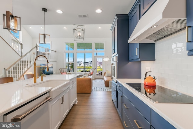 kitchen with pendant lighting, ventilation hood, black electric stovetop, stainless steel dishwasher, and decorative backsplash