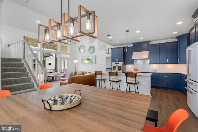 dining area with dark hardwood / wood-style floors and a high ceiling