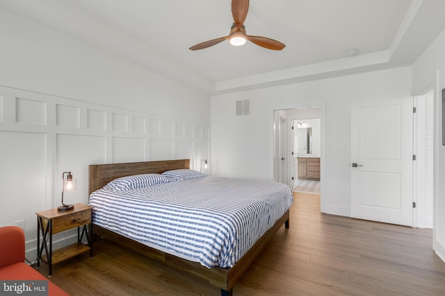 bedroom with ceiling fan, hardwood / wood-style floors, and ensuite bathroom