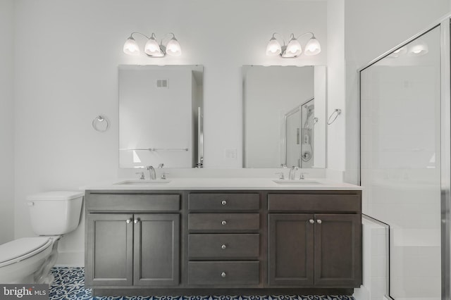 bathroom with tile patterned flooring, a shower with door, vanity, and toilet