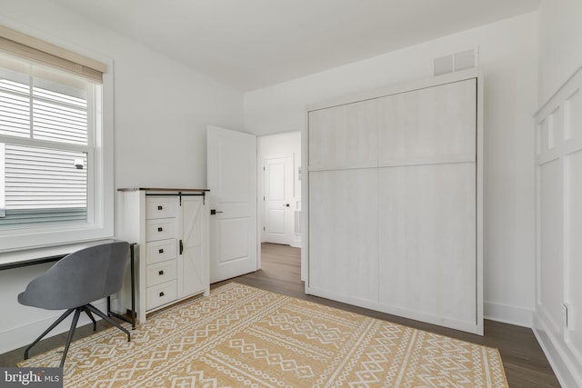 home office featuring hardwood / wood-style floors and a barn door